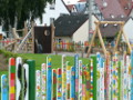 Premium Staketen in diversen Längen und Riegel, bemahlt und als bunter Gartenzaun um Kinderspielplatz